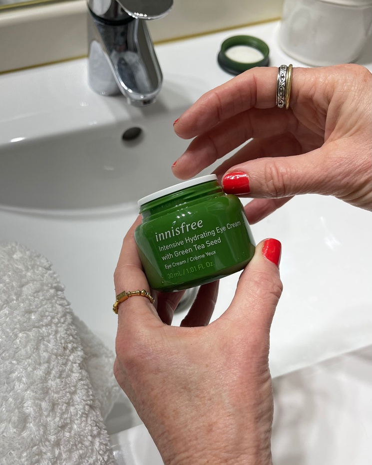 UGC Created photography of a woman holding a pot of eye cream in the bathroom